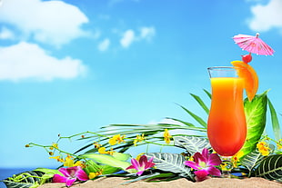 clear glass footed drinking cup filled with orange juice