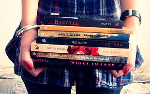 person holding pile of books HD wallpaper