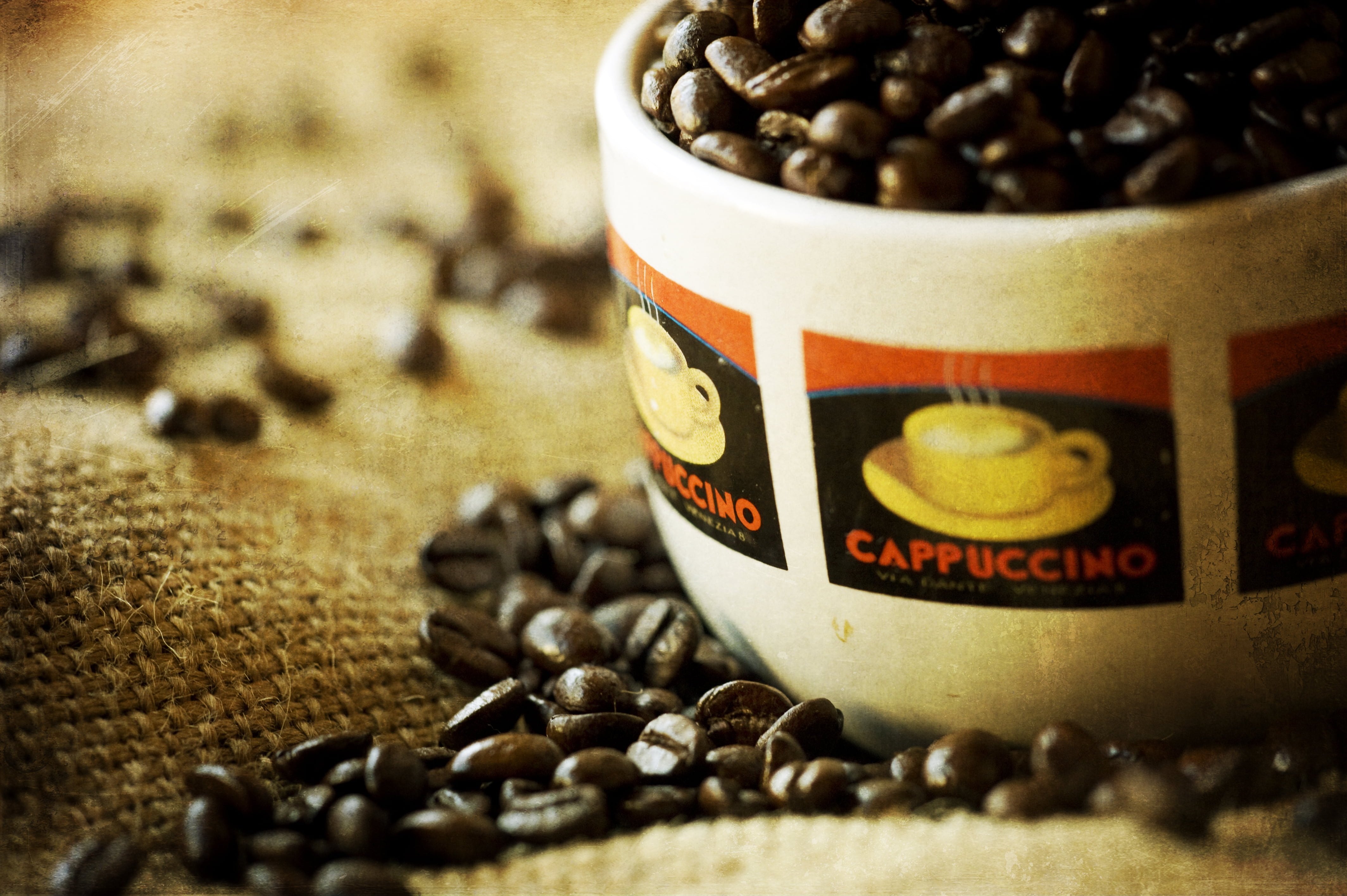 white and black ceramic coffee mug filled with coffee beans