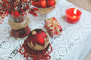 red bauble beside tealight candle on table HD wallpaper