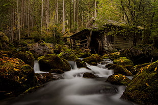 time lapse of waterfalls near brown house at daytime