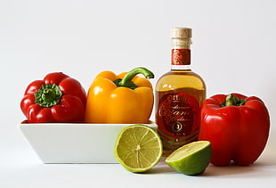 three red and yellow bell peppers, green calamondin, and bottle HD wallpaper