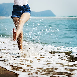 girl in blue short shorts running on seashore HD wallpaper