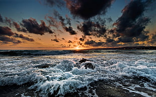 strong ocean waves hammering beach side during sunst HD wallpaper