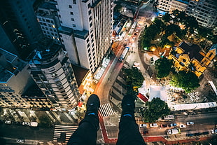 Man Sitting on High Rise Building Taking Photo Below HD wallpaper