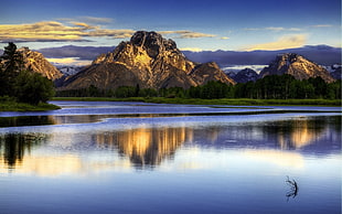 brown mountain rock near body of water during daytimes HD wallpaper