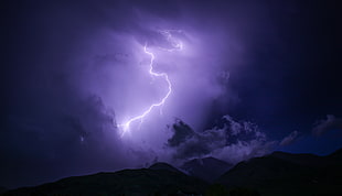 lightning strike above rock formation at night time HD wallpaper