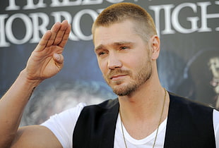 male salute's while standing near gray background