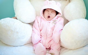 baby in white zip-up hooded pram suit with big white animal plush toy behind HD wallpaper