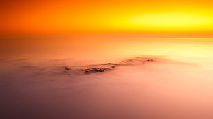 high angle photography of islet covered with fog during golden hour HD wallpaper