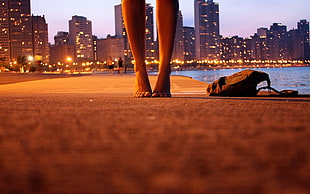 person standing near bag and body of water