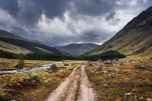 brown road between green mountain range during day time HD wallpaper