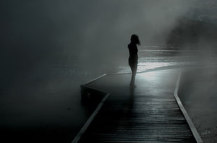 silhouette of woman standing beside sea shore