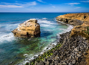 cliff with a view of blue ocean under blue sky HD wallpaper