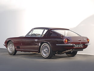 brown coupe parked on concrete pavement