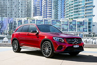red Mercedes Benz 5-door hatchback surrounded by high-rise buildings HD wallpaper