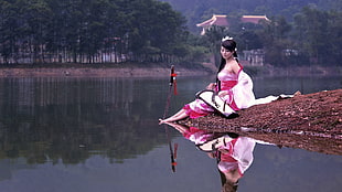 woman sitting near body of water HD wallpaper
