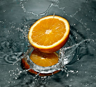 photo of sliced orange fruit splashed on water HD wallpaper
