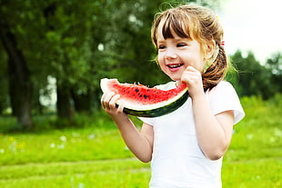 girl holding sliced of watermelon during daytime HD wallpaper
