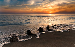 sea waves hitting rock formation near sea shore HD wallpaper