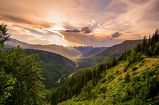 photography of green mountains below of cloudy sky during daytime HD wallpaper