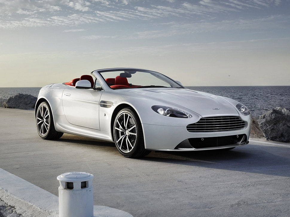 photo of gray convertible coup on roadway beside sea HD wallpaper