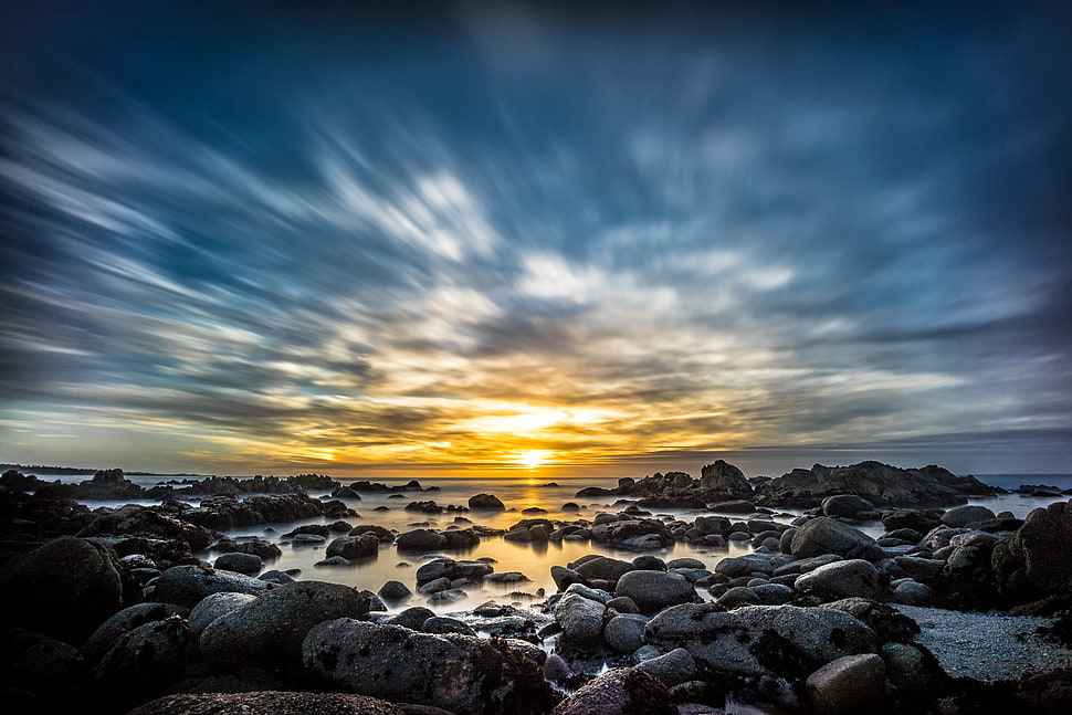 black and gray rock formation at body of water under the blue and brown cloudy sky, sunset drive, monterey HD wallpaper