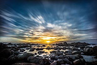 black and gray rock formation at body of water under the blue and brown cloudy sky, sunset drive, monterey HD wallpaper