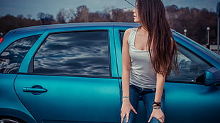 woman leaning on blue 5-door hatchback HD wallpaper