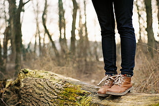 person wearing pair of brown leather boots standing on brown fire wood during day time HD wallpaper
