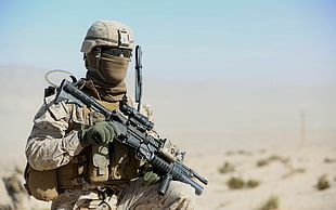 man in brown camouflage print military uniform holding black assault rifle during daytime HD wallpaper