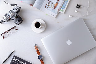 silver MacBook beside the watch