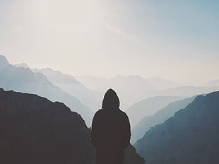 person wearing black hoodie overlooking mountain range HD wallpaper