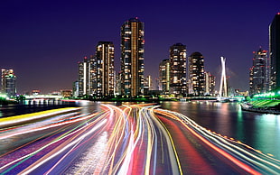 timelapse photography of lights on body of water, city