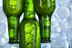 three green glass bottles on top of ice HD wallpaper