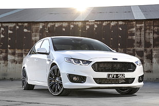 white Ford sedan with gray barn background HD wallpaper