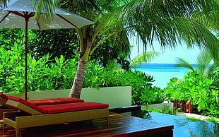 white patio umbrella near a red and brown lounge