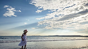 girl wearing white tank top on the sea during daytime