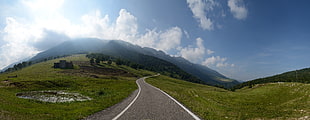 road in between green grass fields, ferrara di monte baldo, italia