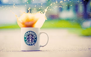 white Starbucks coffee mug with splash of coffee