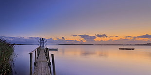 brown wooden dock on body of water under cloudy sky HD wallpaper