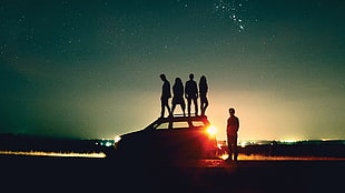 silhouette photography of people standing on top of car during night time HD wallpaper