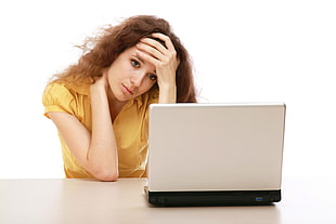 woman wearing yellow button-up shirt looking into gray laptop HD wallpaper