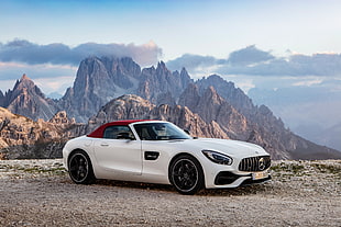 white Mercedes-Benz sports coupe soft top on dirt road near mountain at daytime HD wallpaper