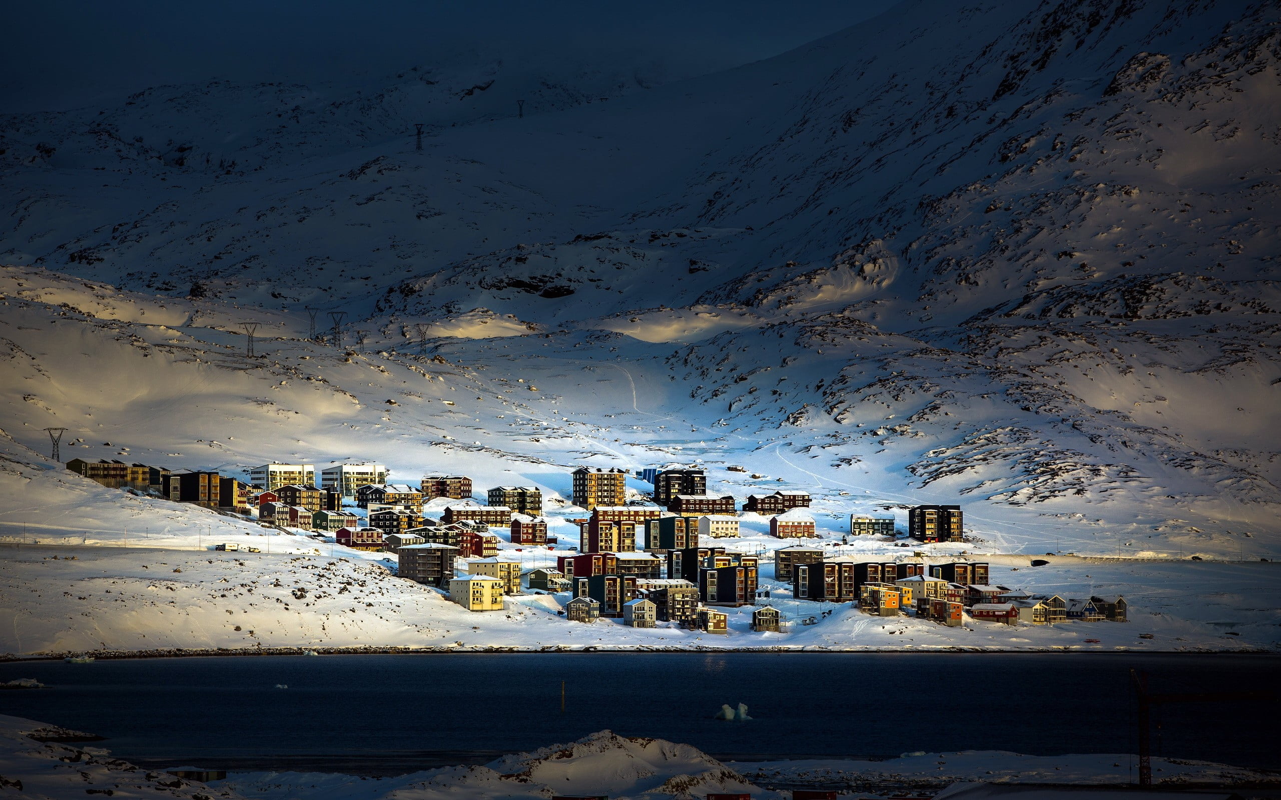 aerial photo of village on the foot of snowy mountain