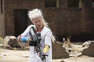 woman holding a gun wearing white short-sleeved top during daytime HD wallpaper