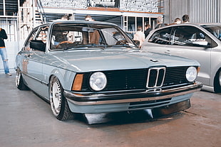 gray BMW 3-series parked near gray 3-door hatchback