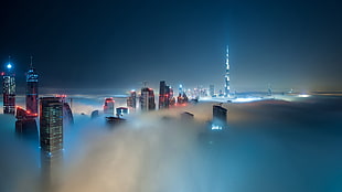 bird's eye view of high rise building surrounded clouds during nighttime HD wallpaper