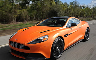 timelapse photography of orange sport car on black asphalt pavement