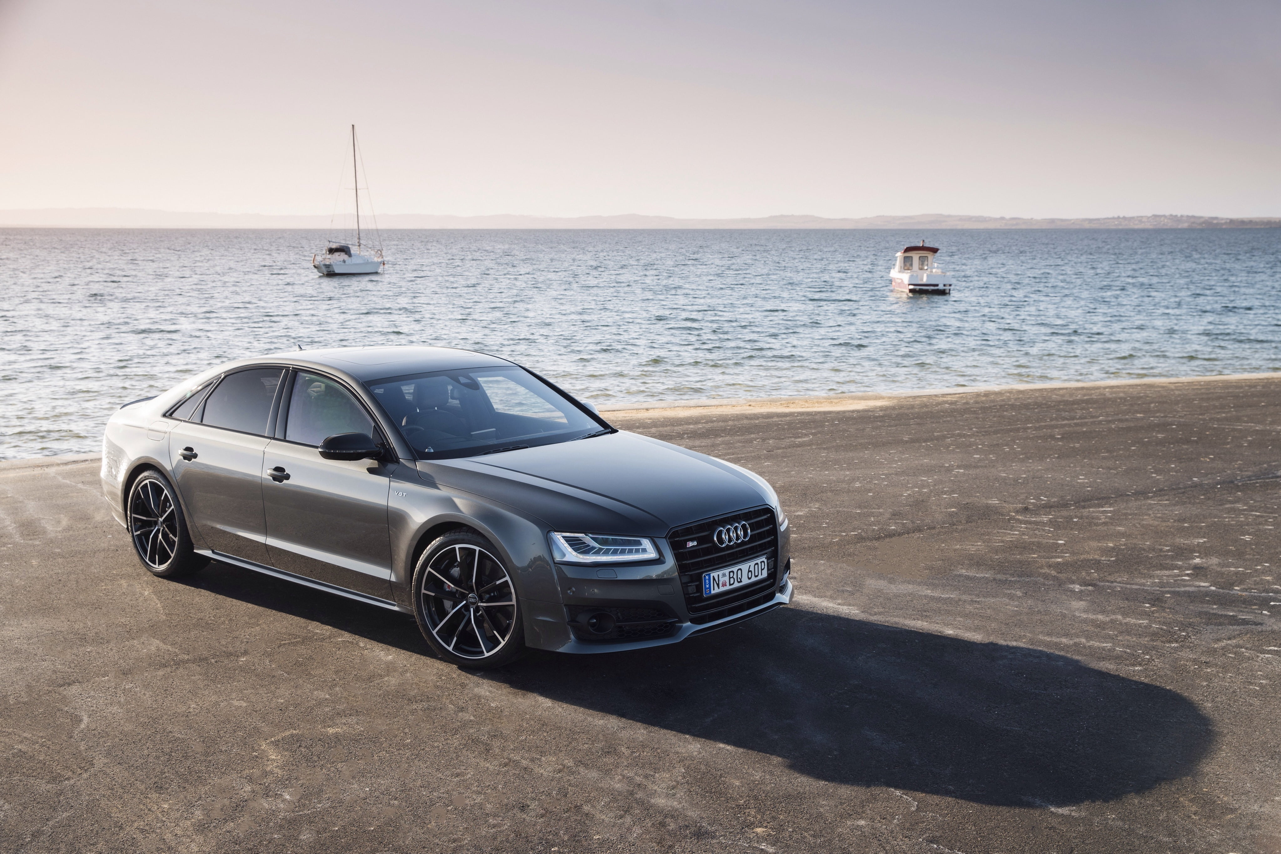 silver Audi A series sedan near boat at daytime